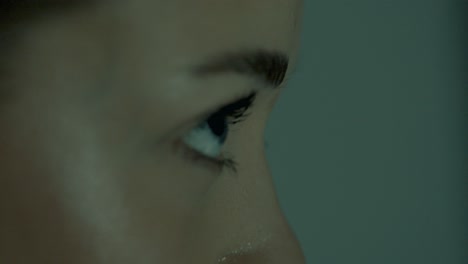 side profile closeup of a woman intensely focused during indoor cycling, her eyes locked straight ahead. cinematic lighting highlights her concentration, strength, and calm control mid-workout