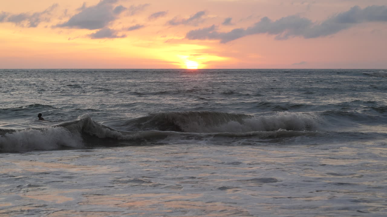 適切な波のセットを待って上下に揺れるサーファーのシルエット