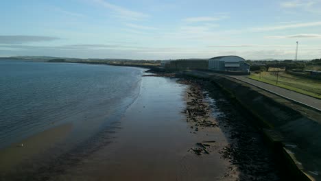 beautiful drone shot flying over coast of scotland with blue sky sunshine