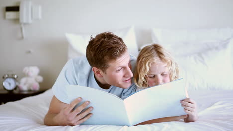 cute child reading a book to his father