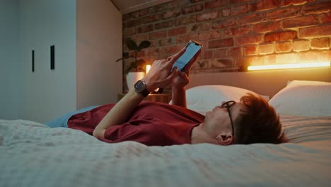 hombre usando el teléfono en la cama