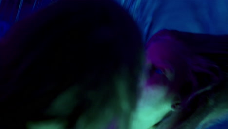 female dancer performing contemporary style moves in neon lighting