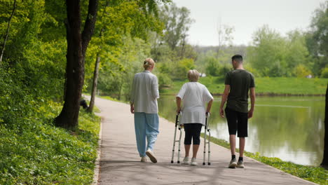 family supporting senior citizens walking in park