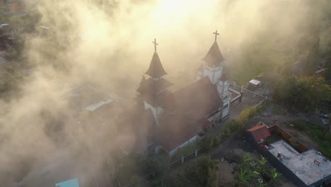 aerial footage of a beautiful church in an indonesian village on a misty day