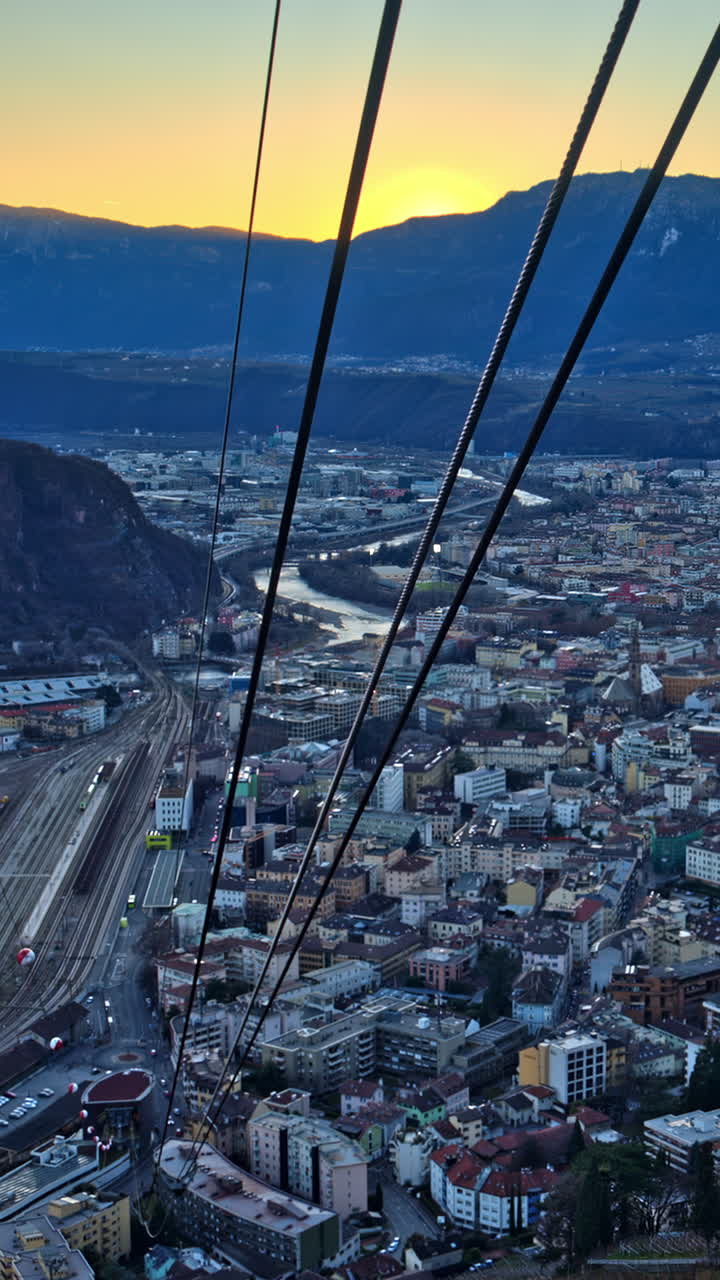 Aerial view from a cableway of a village in the Dolomites, Italy at sunset. Vertical