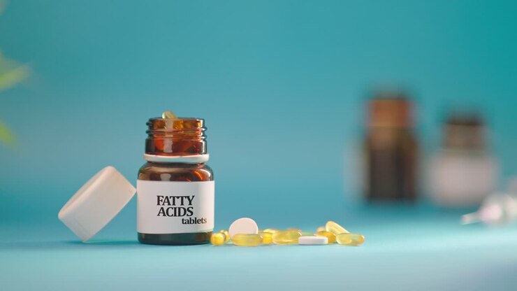 HAND TAKING OUT FATTY ACIDS TABLETS FROM MEDICINE BOTTLE