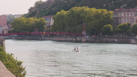 passerelle saint-vincent and a white boat on saone river at sunset in lyon, rhone, france, wide shot