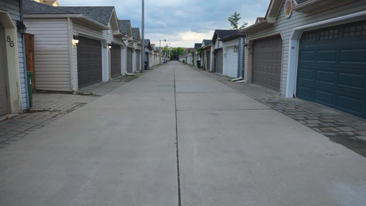 Beco vazio em uma vila residencial no Canadá com portões de casas fechados - plano aberto