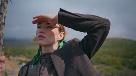 portrait girl admiring mountains on trip. hiking woman cover face from sunlight