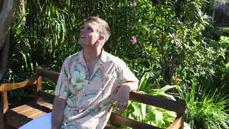 Young-caucasian-male-sitting-on-park-bench-talking-and-laughing_slow-motion