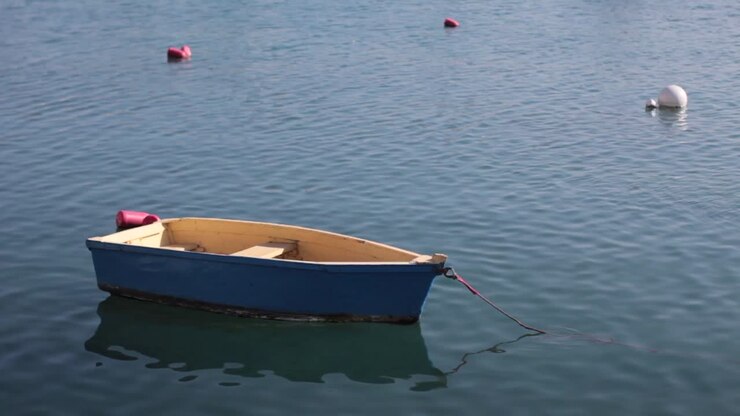 Piccola barca da pescatore blu che galleggia placidamente nell'acqua
