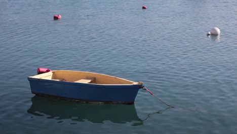 Pequeño-Barco-De-Pescadores-Azul-Flotando-Tranquilamente-En-El-Agua