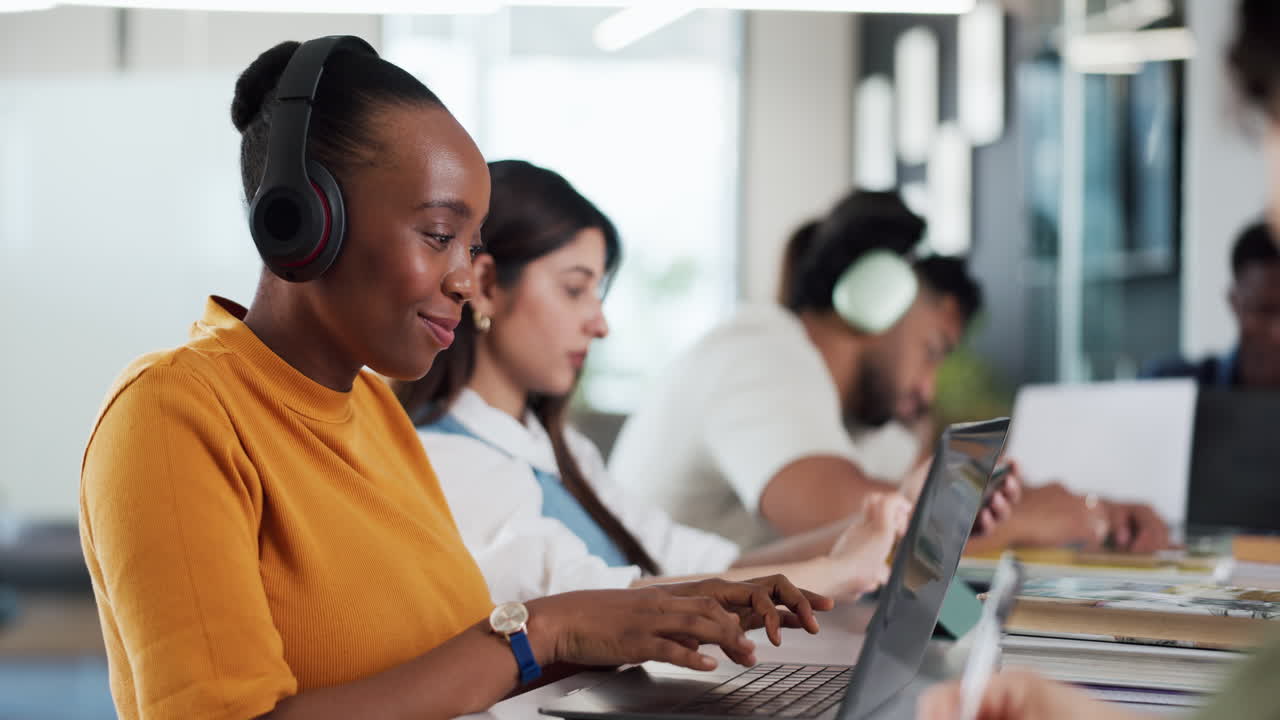Young Woman in Headphones Working on Laptop in Modern Office