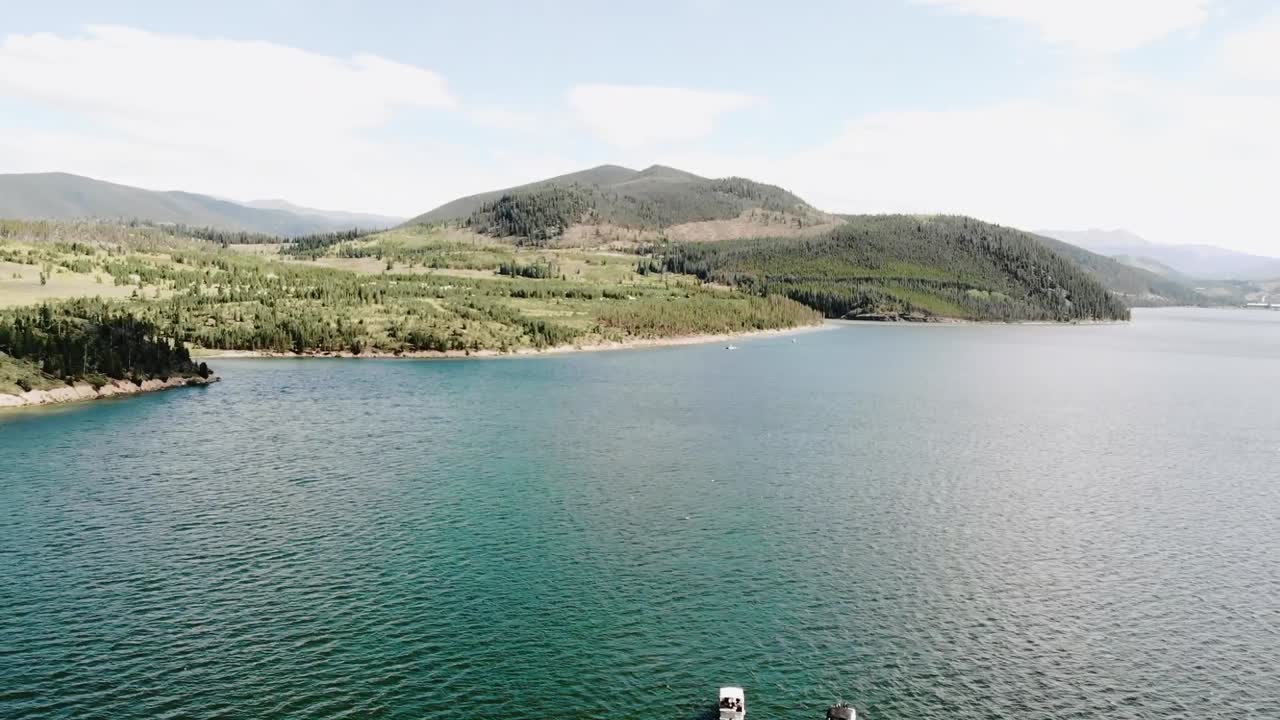 Aerial view of people enjoying a boat ride on a beautiful lake surrounded by mountains