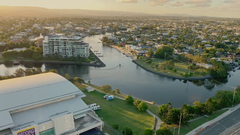 4k uhd panning view of convention and exhibition centre on the nerang river at sunset in downtown broadbeach district, gold coast australia, aerial view