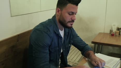 Serious-bearded-man-using-laptop-in-cafe