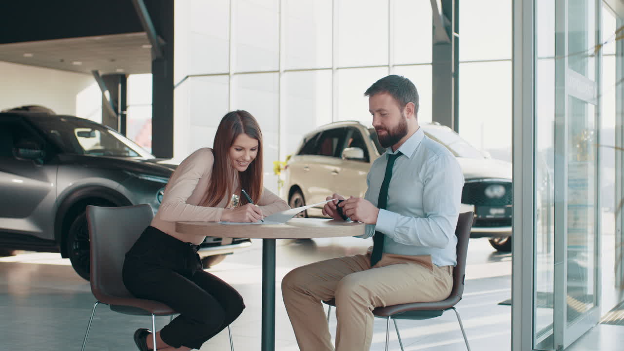 cliente firmando documentos de compra de automóviles en el concesionario