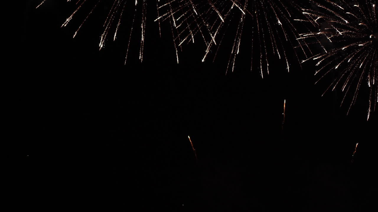 Fuochi d'artificio bianchi e luminosi piovono dall'alto della cornice video, riempiendola progressivamente.
