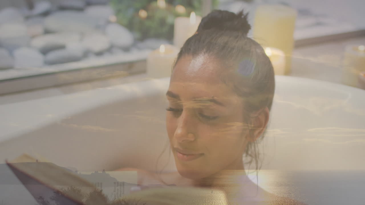 woman reading book in bathtub spa scene, showing animated candle flames and floating stone icons
