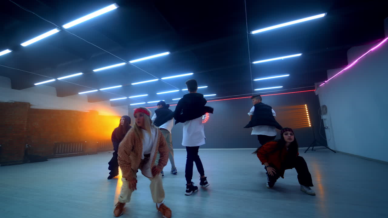 Mixed boys and girls band dancing hip hop. Young people active lifestyle. Dance studio backdrop.