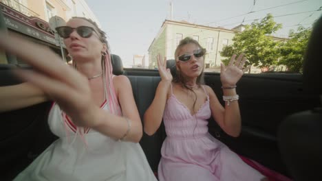 two women enjoying a convertible ride