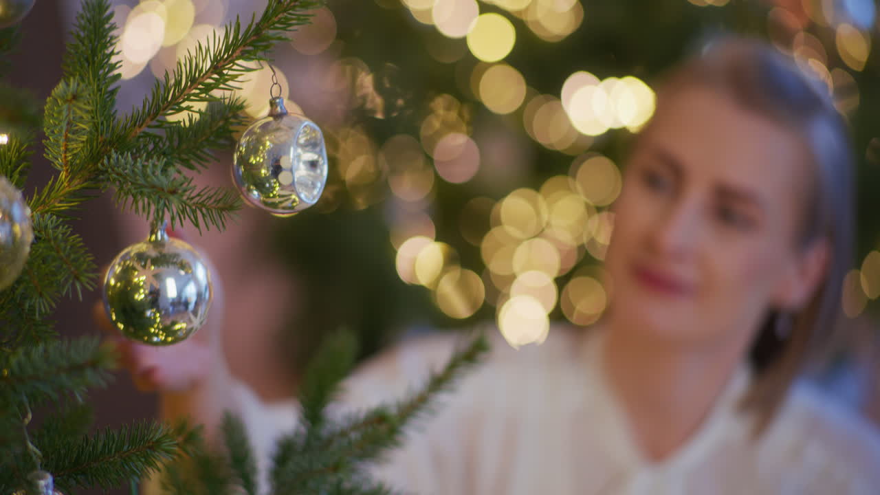 mujer sonriente decorando el árbol de navidad durante la navidad