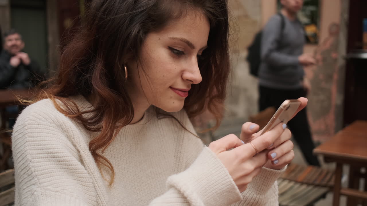 mujer revisando las redes sociales en el teléfono inteligente en la terraza