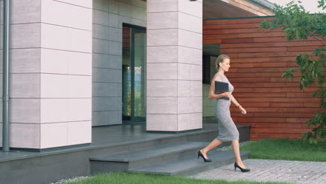 Mujer-De-Negocios-Saliendo-Del-Edificio-De-Oficinas-Con-Una-Computadora-Portátil.