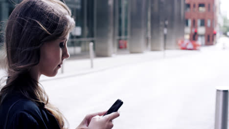attractive business woman commuter using smartphone in city of london