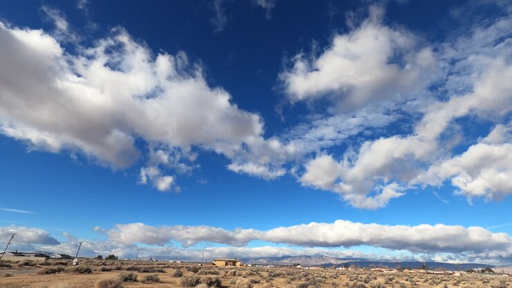 Timelapse de nubes esponjosas en un cielo azul vibrante sobre el árido desierto de Mojave