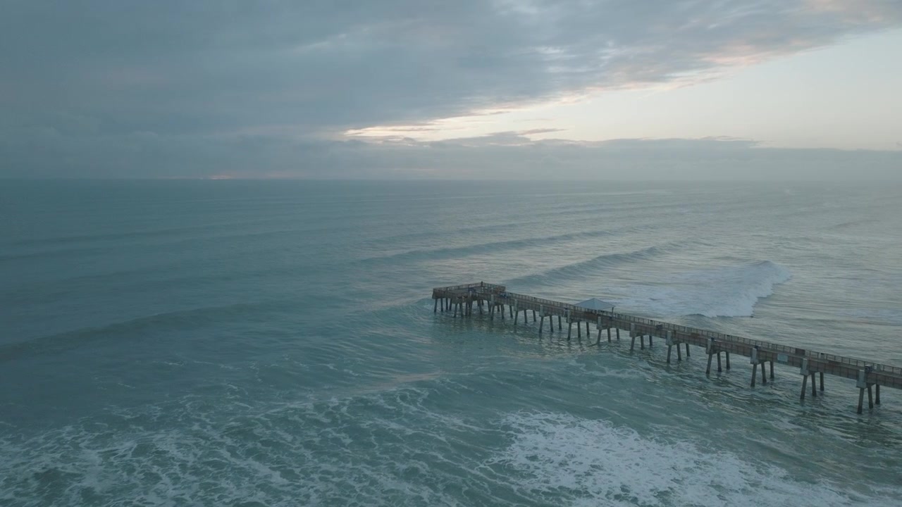 Volo con drone all'alba sulla spiaggia della Florida, presso il molo di Jupiter