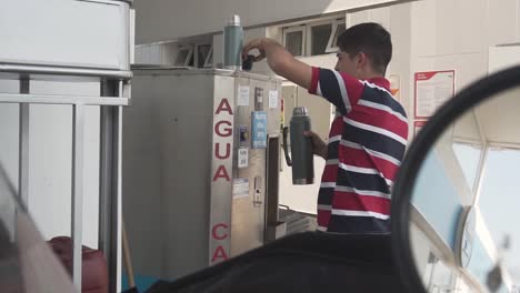 man buying hot water for mate from a vending machine, argentina. gimbal, slomo