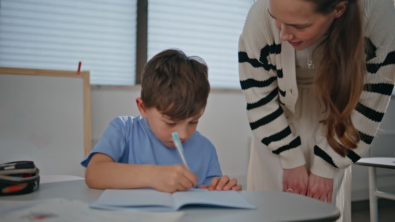 Smart boy writing copybook at lesson closeup. Small schoolboy learning class