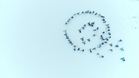 group of people skiing and snowboarding in a circle formation in the snow