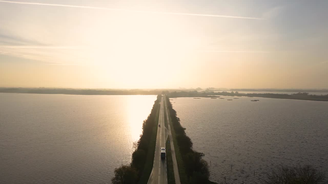 호수를 가로지르는 도로 위에서 해가 뜨거나 해가 지는 것