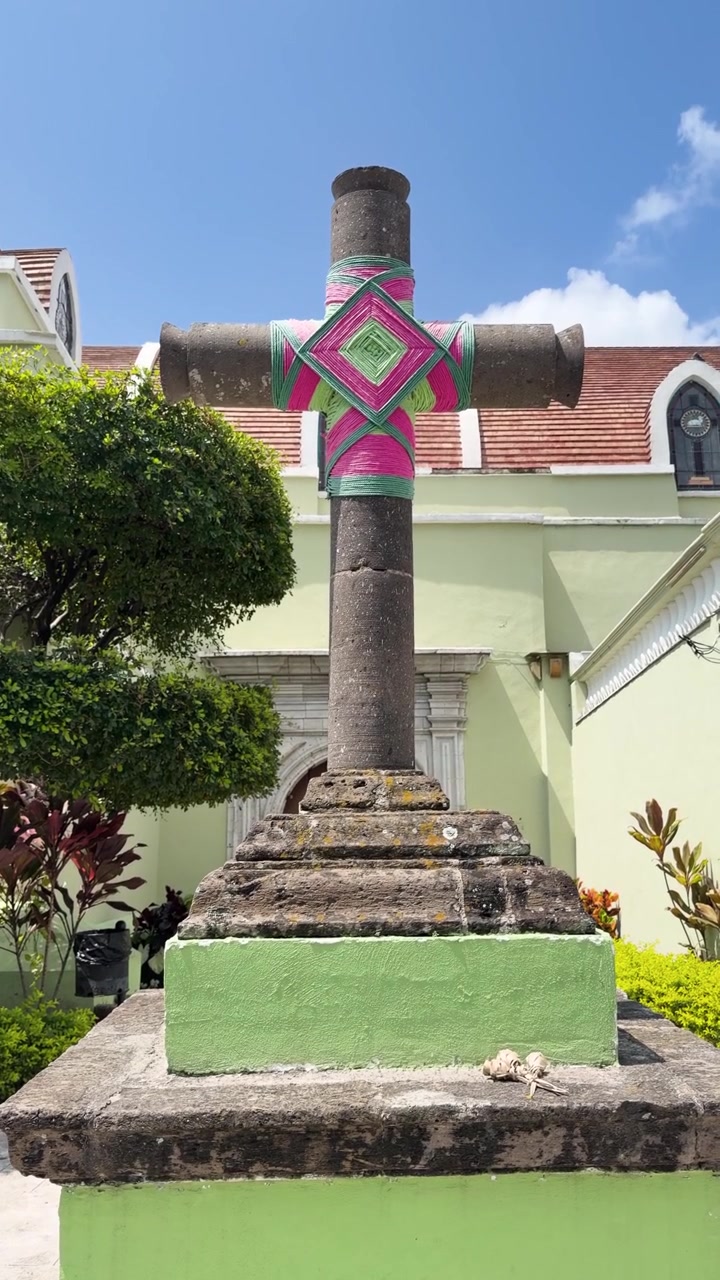Croce di pietra decorata con arte in filo Wixarika davanti alla chiesa. Nayarit, Messico.