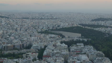 expansive aerial shot over athens with green hill and city expanse