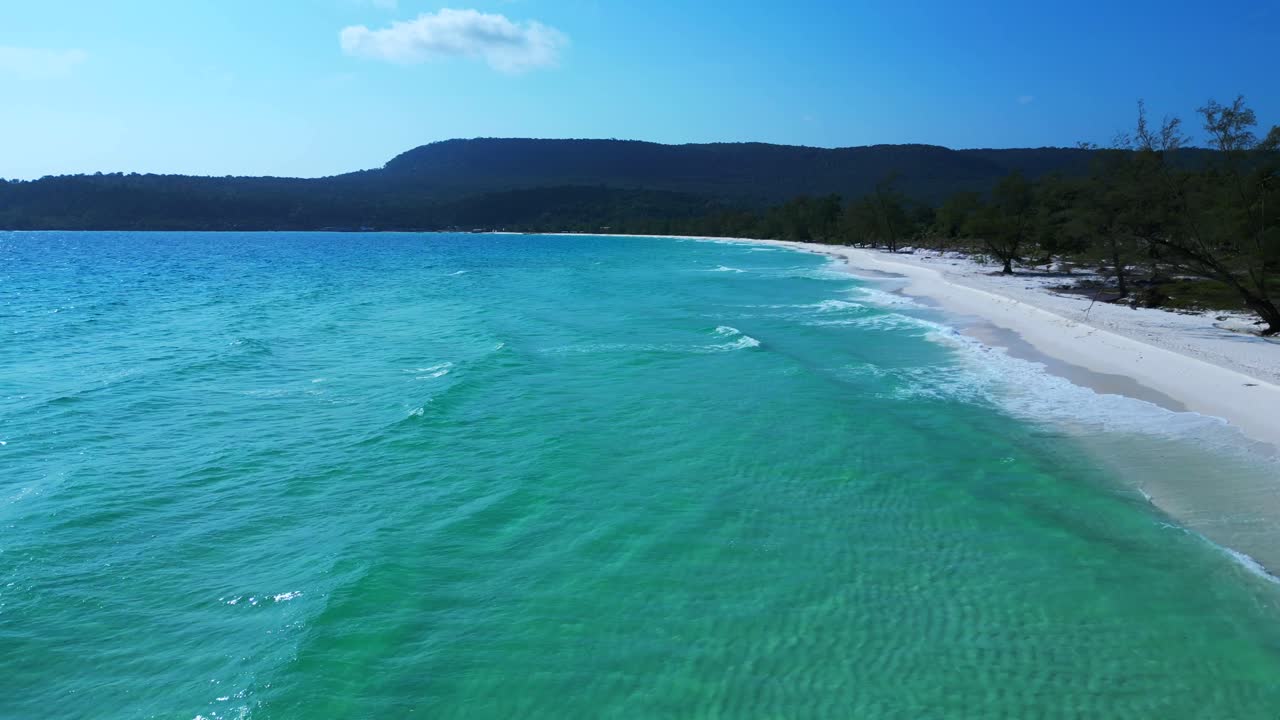 Tropical landscape showing turquoise sea washing white sand beach and green rainforest covering Koh Rong island in Cambodia. Nice aerial view flight dolly right drone