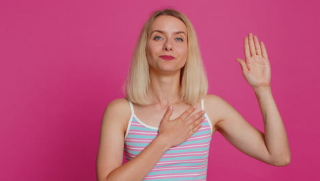 woman raising hand to take oath promising to be honest and to tell truth keeping hand on chest