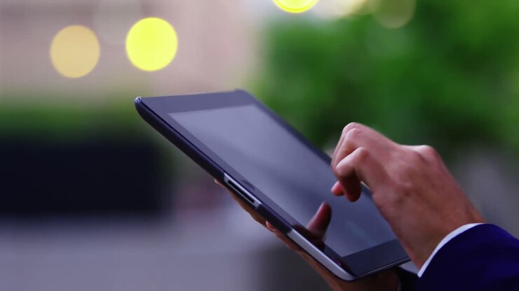 Donna d'affari in piedi per strada che usa il tablet