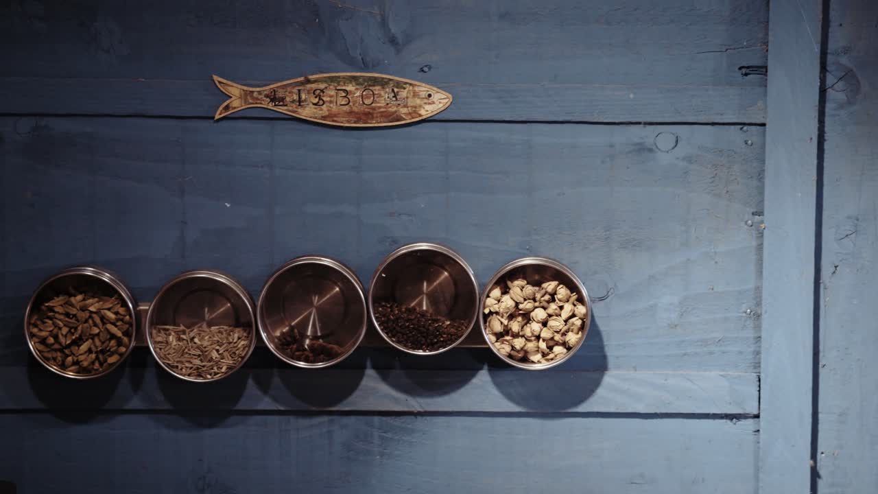 Schalen mit Gewürzen und Fisch auf blauem Hintergrund, symbolisieren kulinarische Tradition, erdige Töne