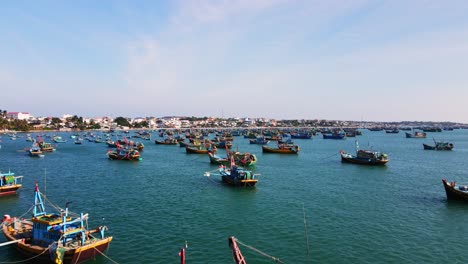 Colorful-fishing-boats-anchored-in-bay,-fishing-industry,-Mui-Ne,-Vietnam