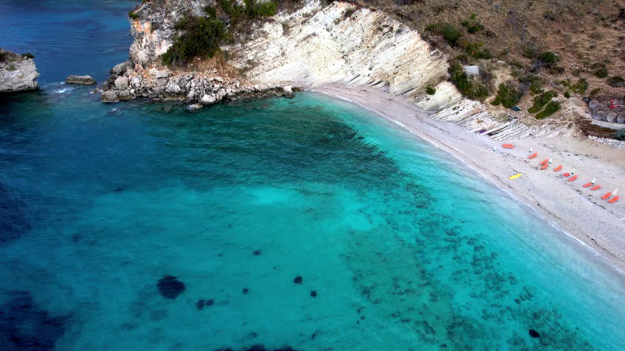 Aerial pan of sandy beach near Ksamil Albania of Ionian sea.