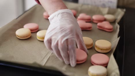 female hands putting filled macaroons in a tray