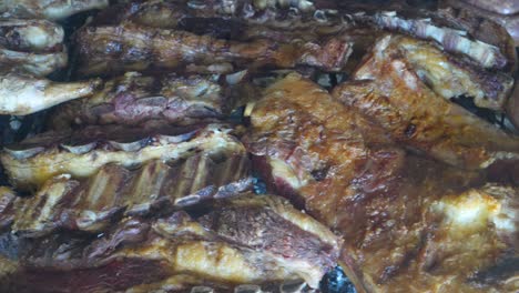 chorizos, beef and chicken meat cooking on a grill in an argentinian asado