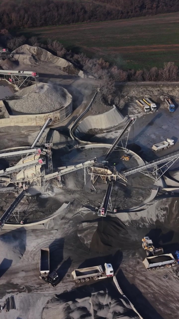 Working area in a large quarry during day with machinery in action