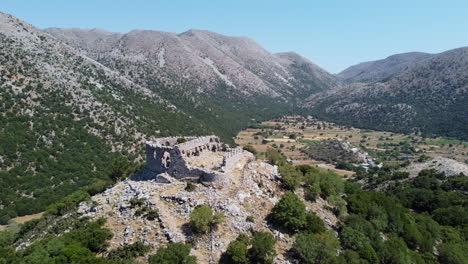 Vista-Aérea-Sobre-Las-Ruinas-De-La-Fortaleza-Del-Castillo-Turco-En-Las-Montañas-Leuka-Ori-Y-El-Desfiladero-De-Improu,-Askifou-Creta