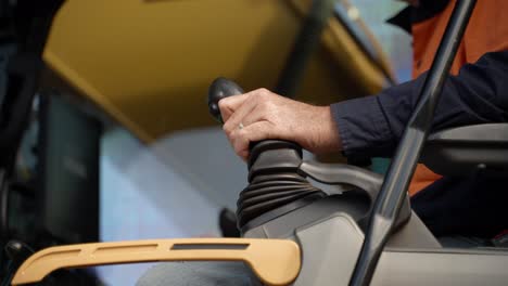 a man inside an excavator cabin moving the controls