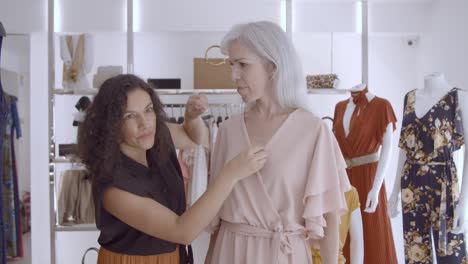 cheerful shop seller helping female customer