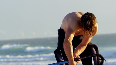 Male-surfer-preparing-windsurfer-in-the-beach-4k